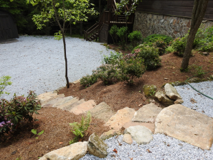 View from the top of stone steps to parking area by Gonzalez Landscaping and Home Improvement